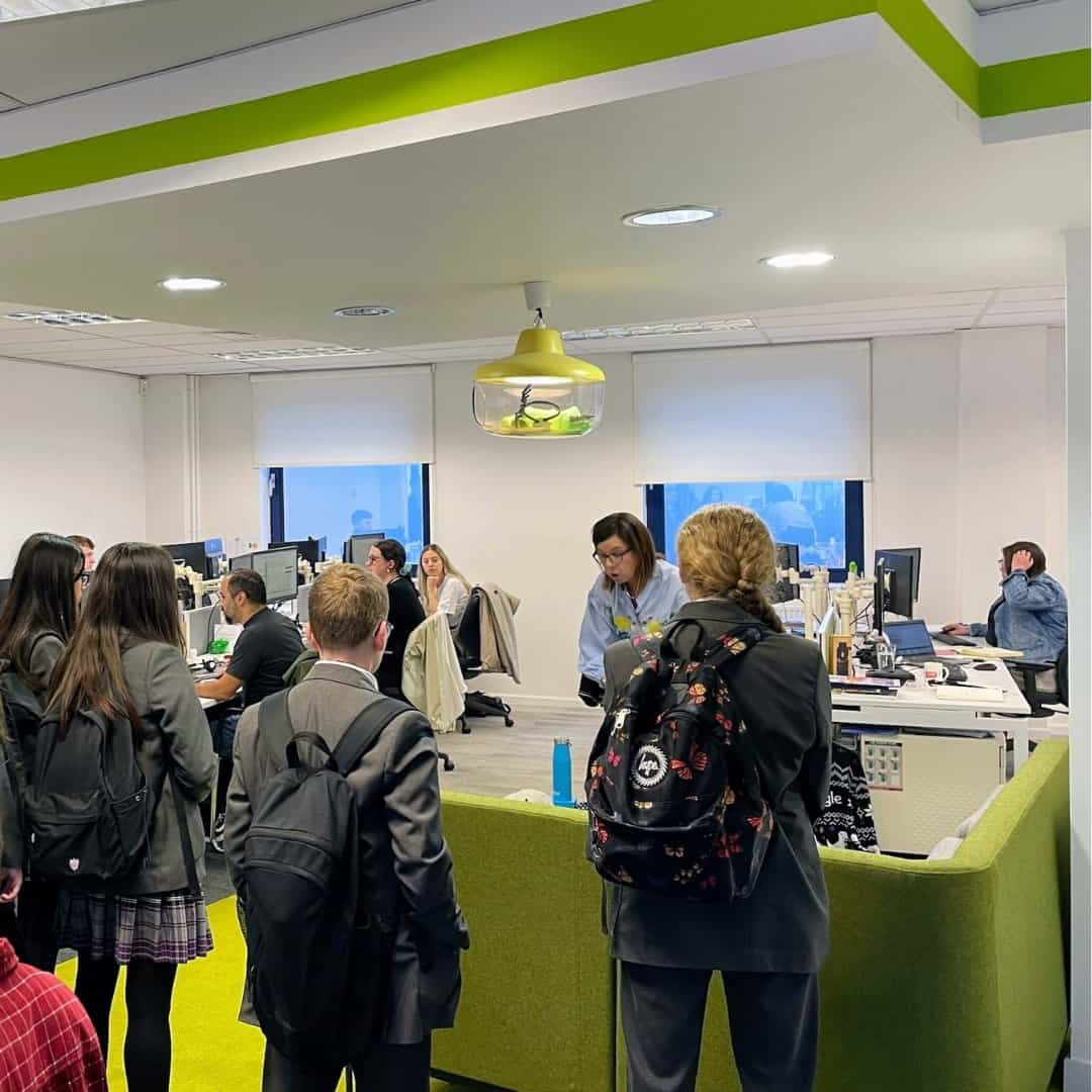 Year 8 students from Laurus Cheadle Hulme stand in a green Brand Addition office.