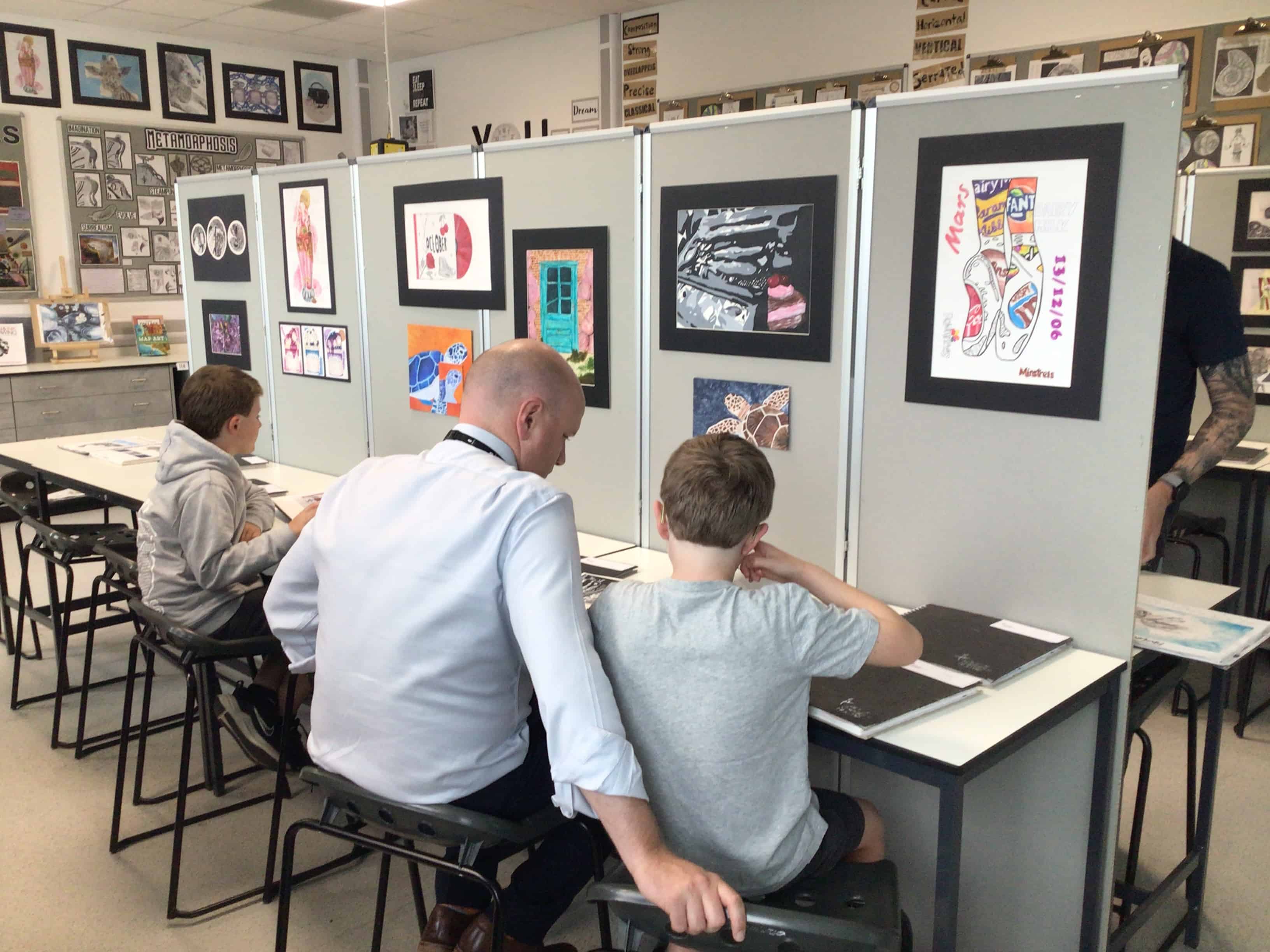 A teacher and his children enjoy looking at the GCSE artwork from Laurus Cheadle Hulme students